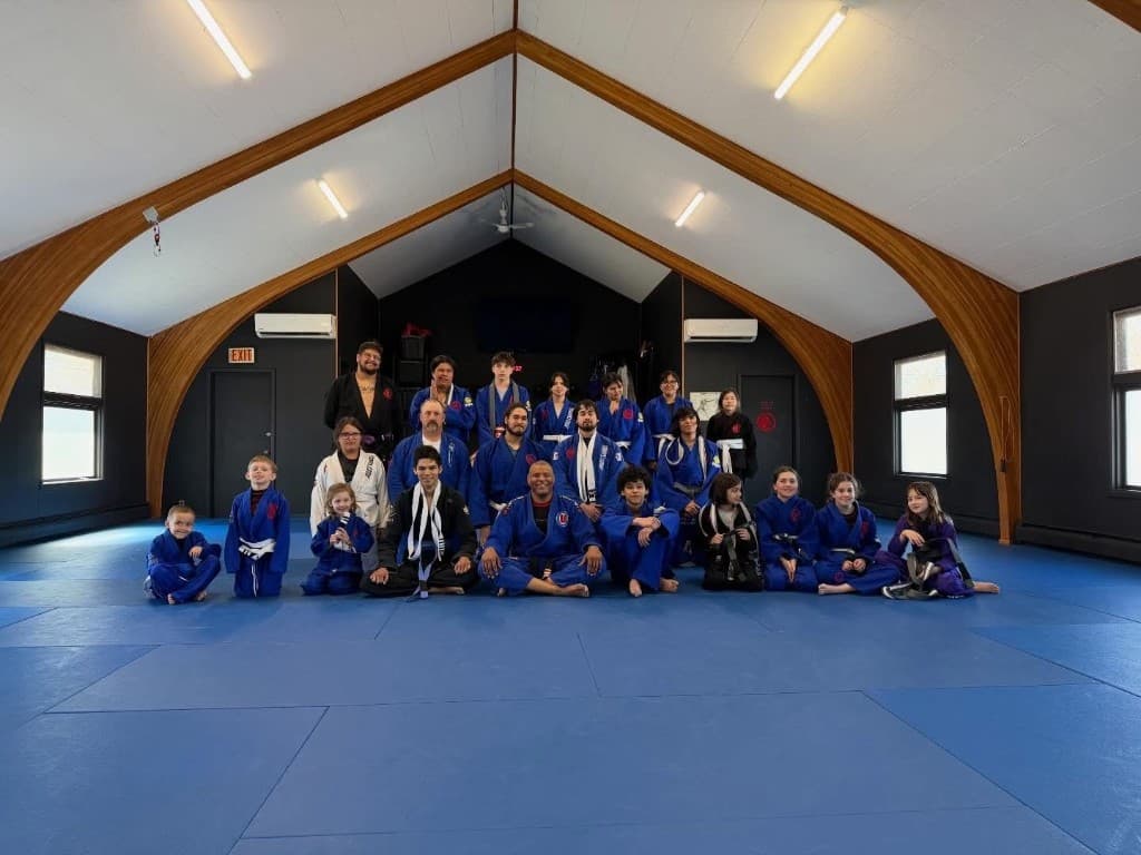Mahingan Martial Arts students and coaches in a group BJJ class on blue mats