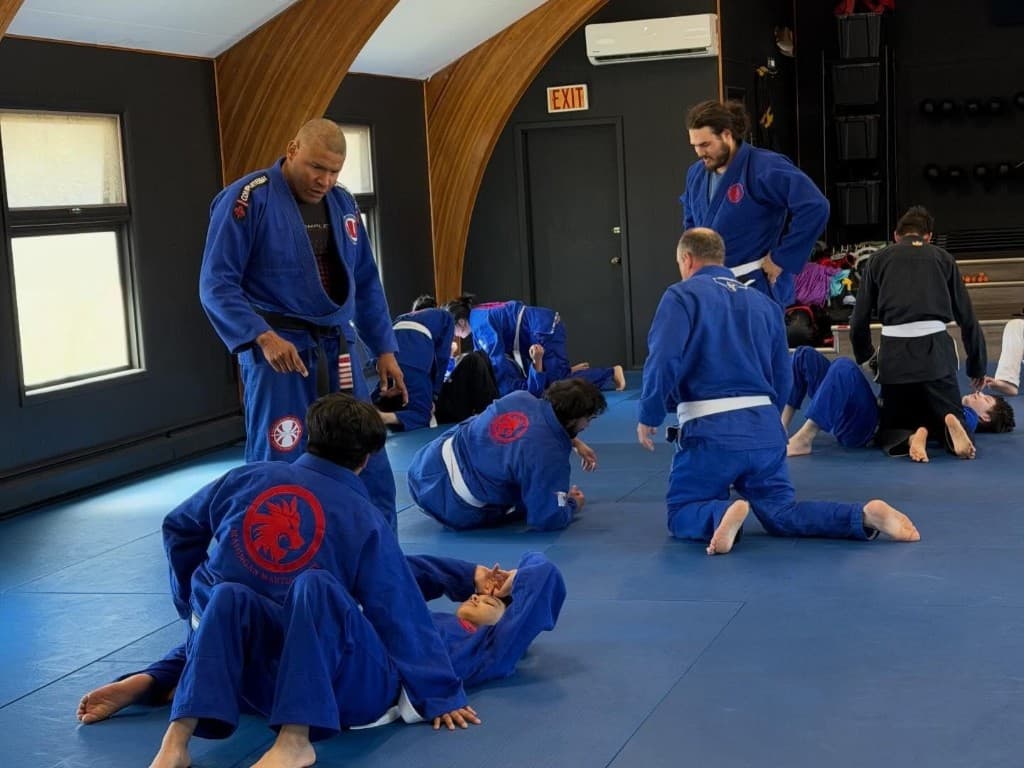 Coach instructing students during Brazilian Jiu-Jitsu training on the mats