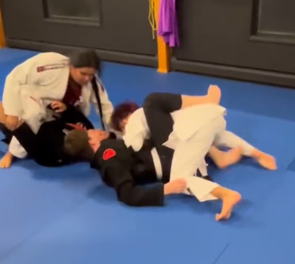 Students practicing Brazilian Jiu-Jitsu grappling during class